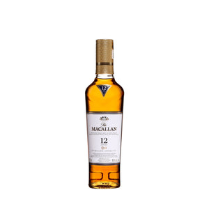 "Botella de Whisky Macallan 12 Años Double Cask 350 ml con vaso servido, reflejando su color ámbar dorado y su sofisticación."