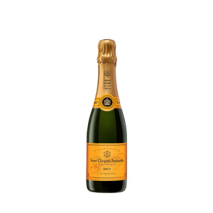 "Botella de Champagne Veuve Clicquot Yellow Label 375 ml con copa servida, reflejando su vibrante color dorado y burbujas finas."